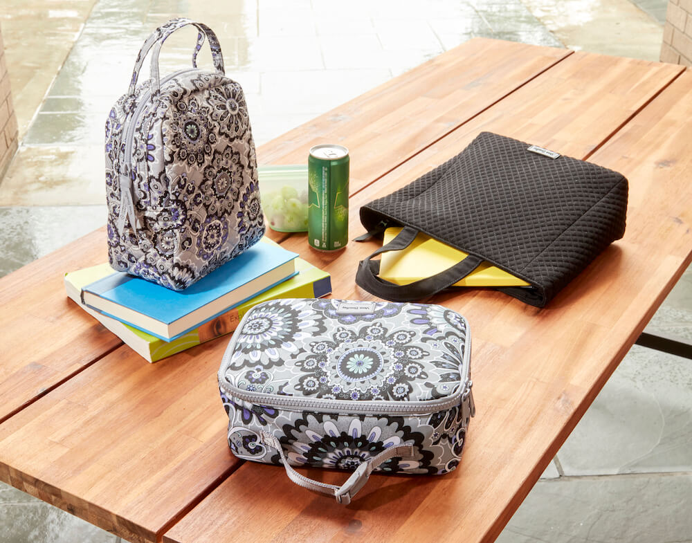 Vera Bradley lunch bags and small tote bag with books on school lunch table