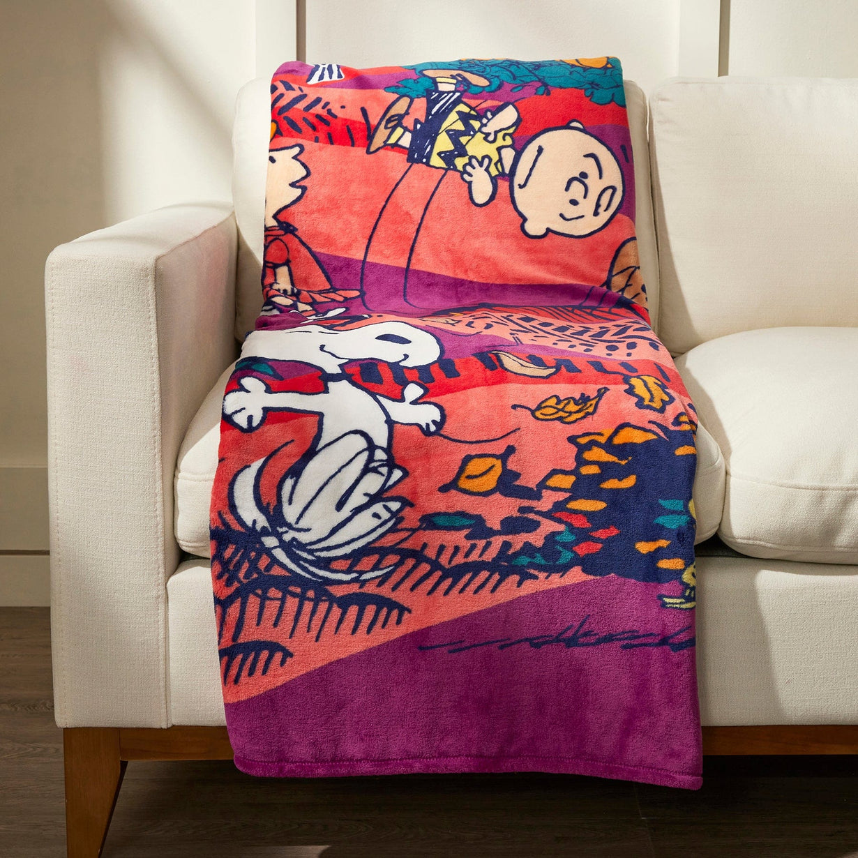 Peanuts fleece throw blanket laying on couch