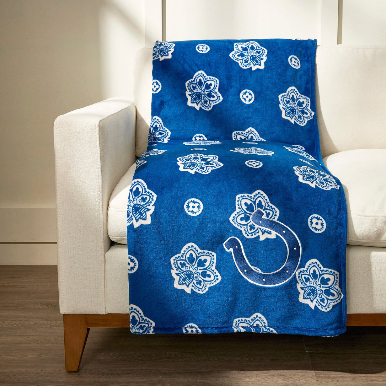Blue fleece blanket with Indianapolis Colts logo draped across beige chair