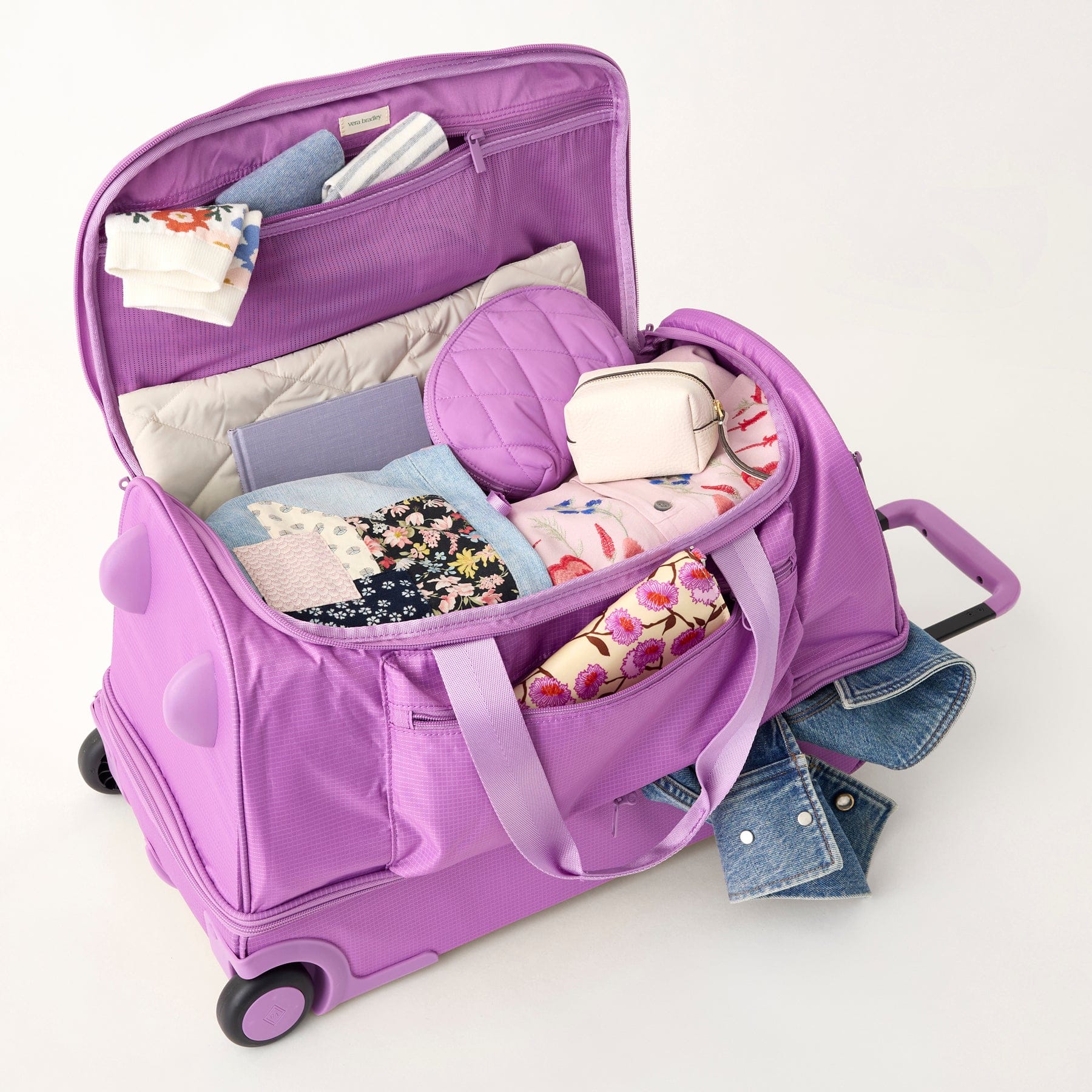 light purple duffel bag with wheels shown open and filled with clothes and makeup bag