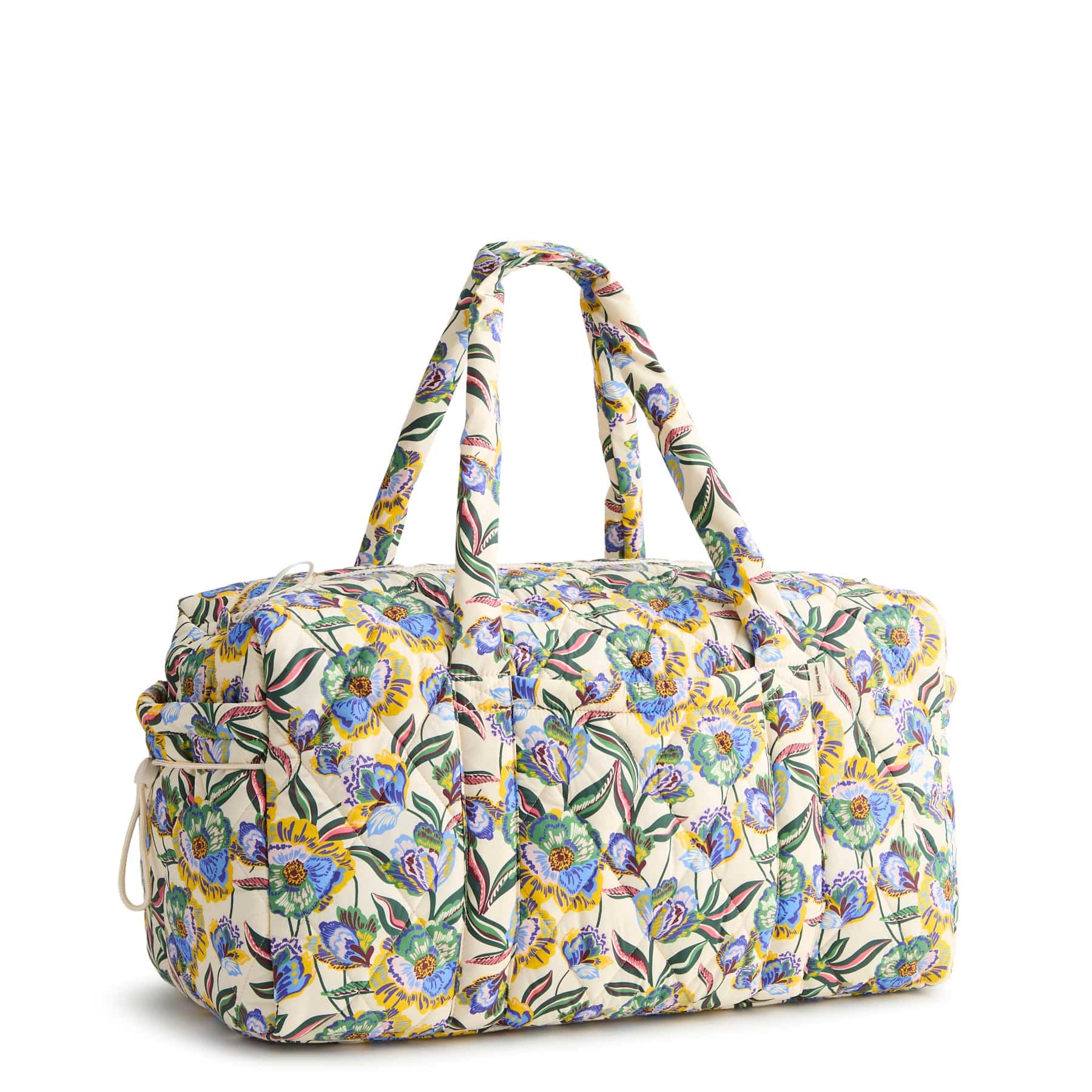 large cream colored duffel bag with two handles and blue green and yellow floral pattern