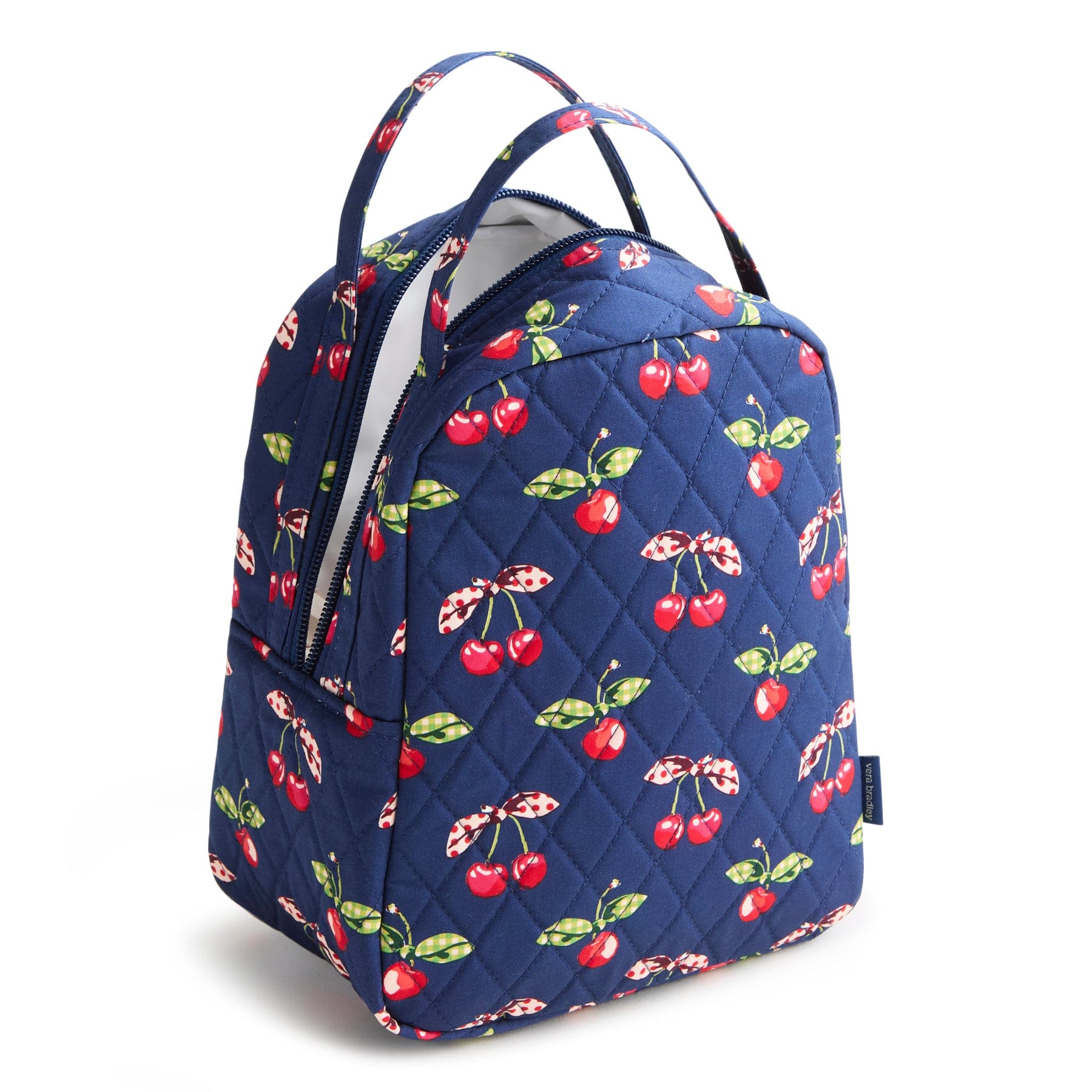 navy blue quilted cotton lunch bag with red cherries pattern and two handles shown with top compartment unzipped an insulated interior