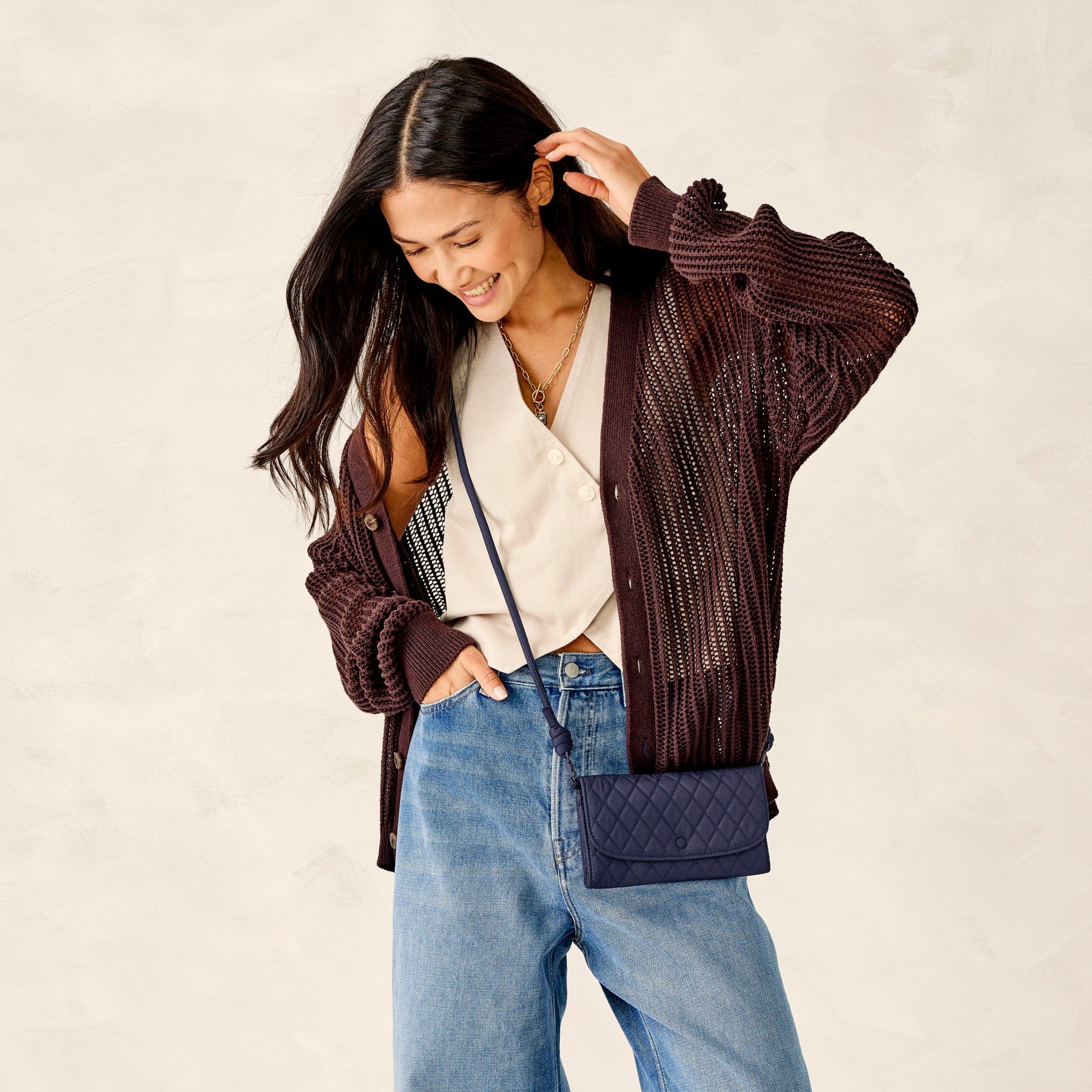 model in casual clothes with dark blue quilted cotton crossbody wallet purse slung across hip