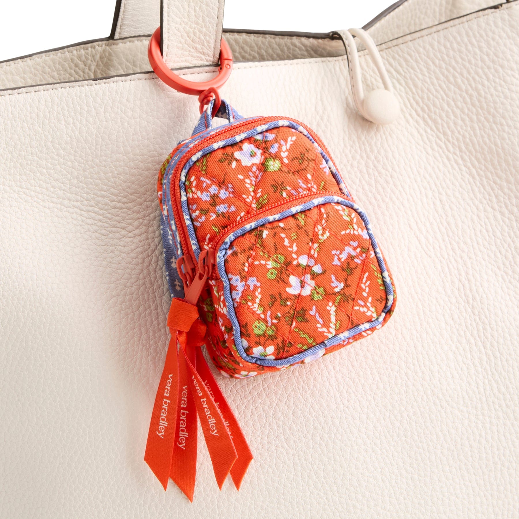 miniature red floral vera bradley backpack bag charm shown with metal hinge ring around handle on cream leather purse