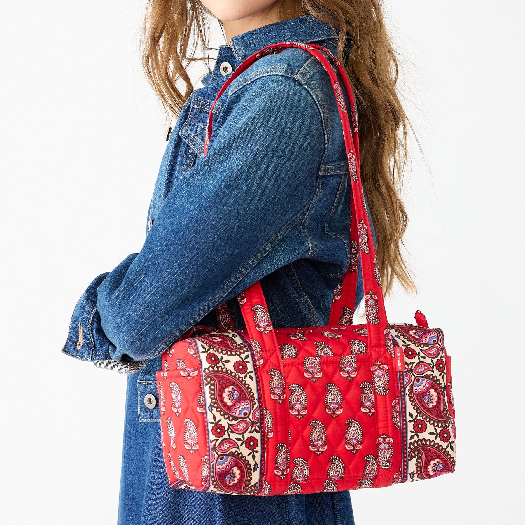 model wearing denim shirt with red quilted cotton vera bradley original handbag over shoulder