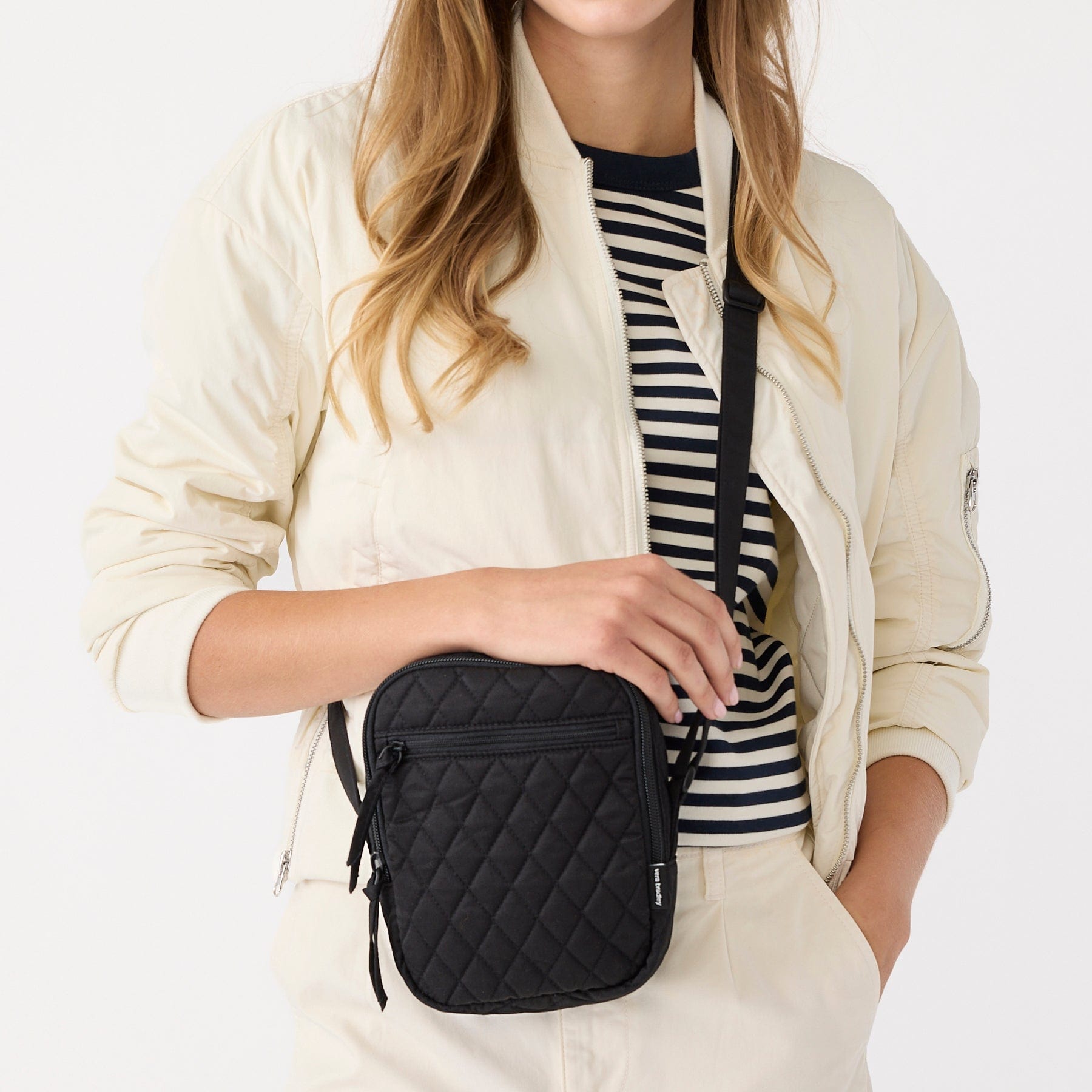 Model wearing black leather wallet crossbody bag slung over shoulder