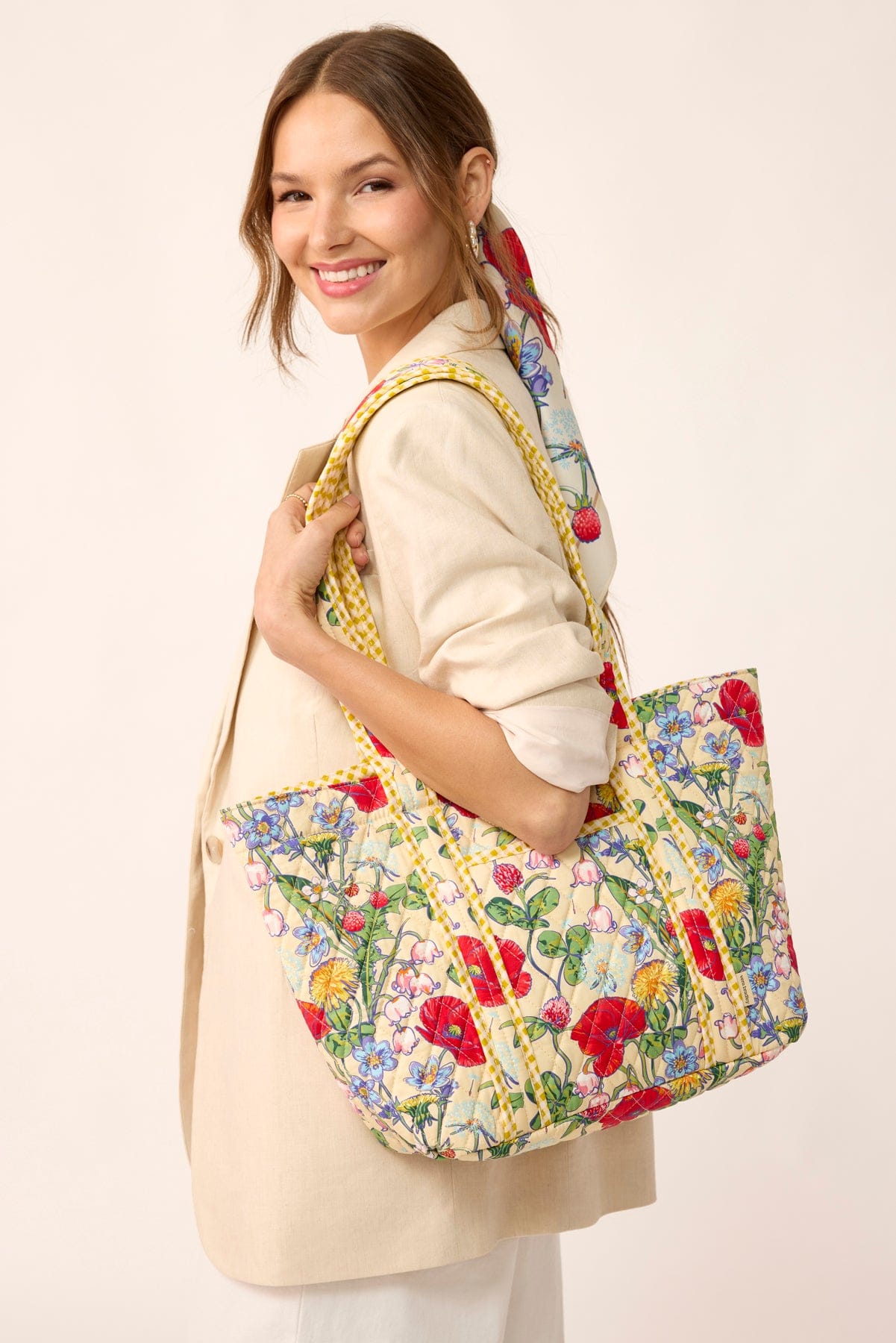 model wearing pale yellow blazer large yellow quilted cotton tote bag with wildflowers pattern slung over shoulder