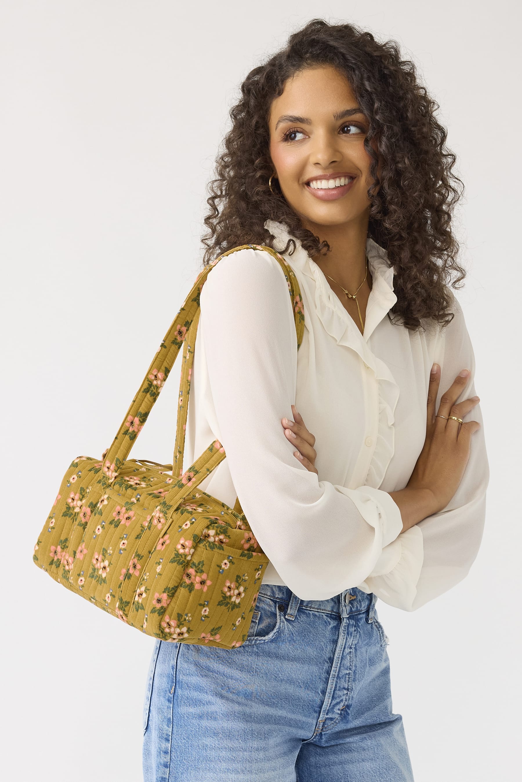 model wearing white blouse and jeans with handbag in mustard yellow ribbed corduroy with floral pattern and long handles