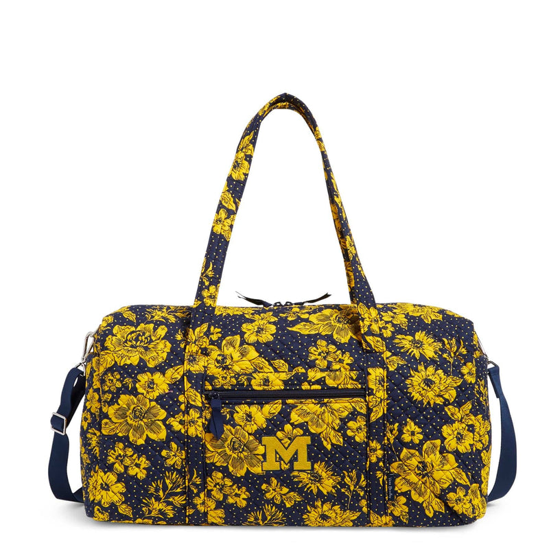 Large navy blue travel duffel bag with yellow floral pattern and University of Michigan logo